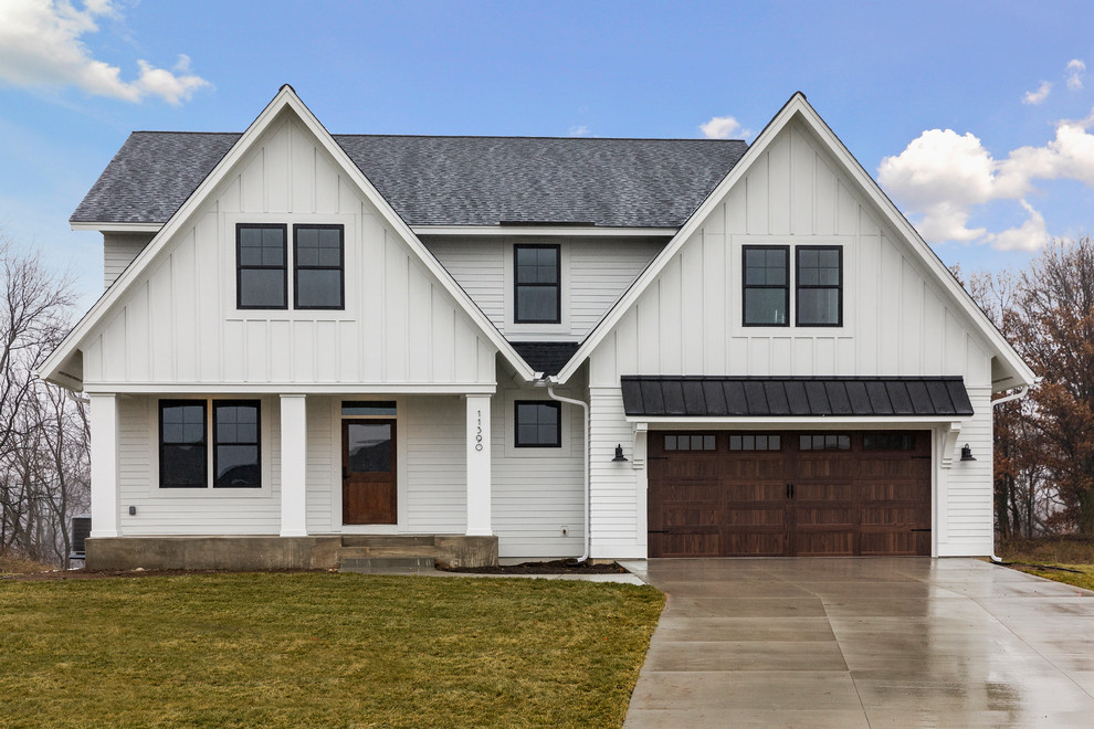 Photo of a country two-storey white house exterior in Minneapolis with vinyl siding, a gable roof and a shingle roof.