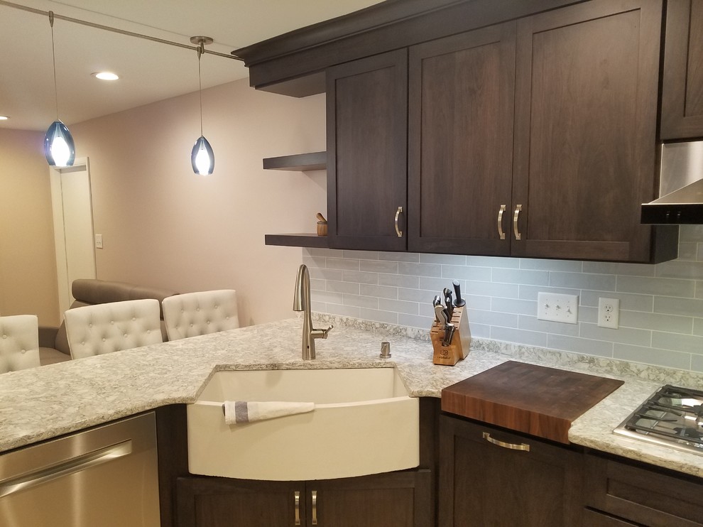 Example of a large transitional l-shaped porcelain tile and beige floor eat-in kitchen design with a farmhouse sink, shaker cabinets, black cabinets, quartz countertops, blue backsplash, ceramic backsplash, stainless steel appliances, a peninsula and white countertops