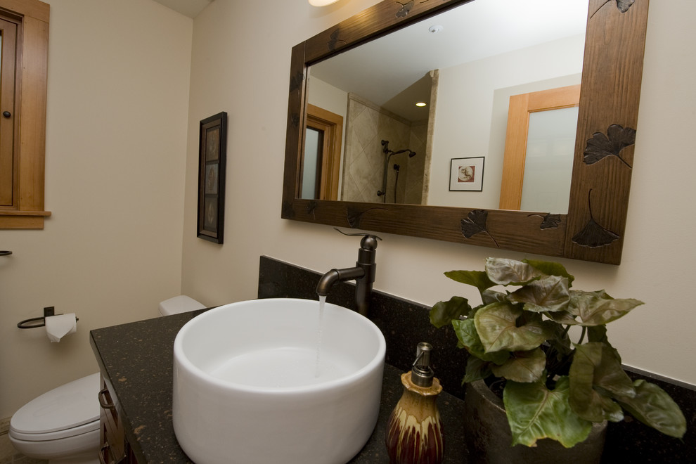 This is an example of a small traditional 3/4 bathroom in San Francisco with shaker cabinets, medium wood cabinets, a two-piece toilet, white walls, a vessel sink, beige floor, black benchtops, a single vanity and a built-in vanity.