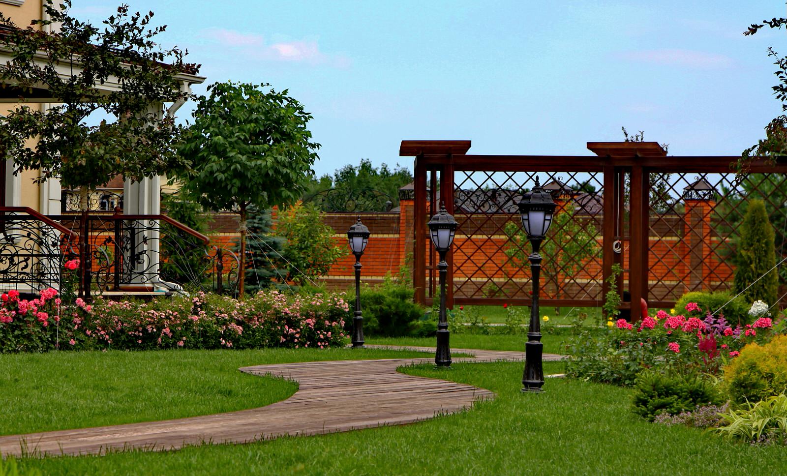 Часть дорожки, цветник с розами и пергола
