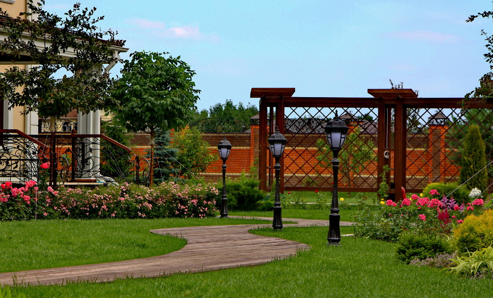 Часть дорожки, цветник с розами и пергола