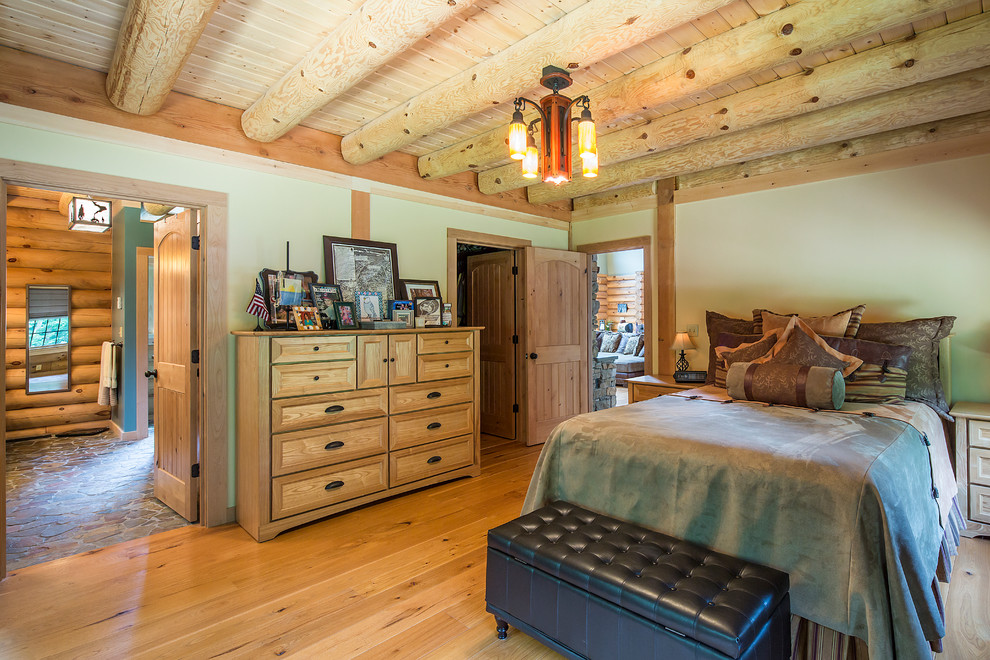 Country master bedroom in Burlington with green walls and medium hardwood floors.