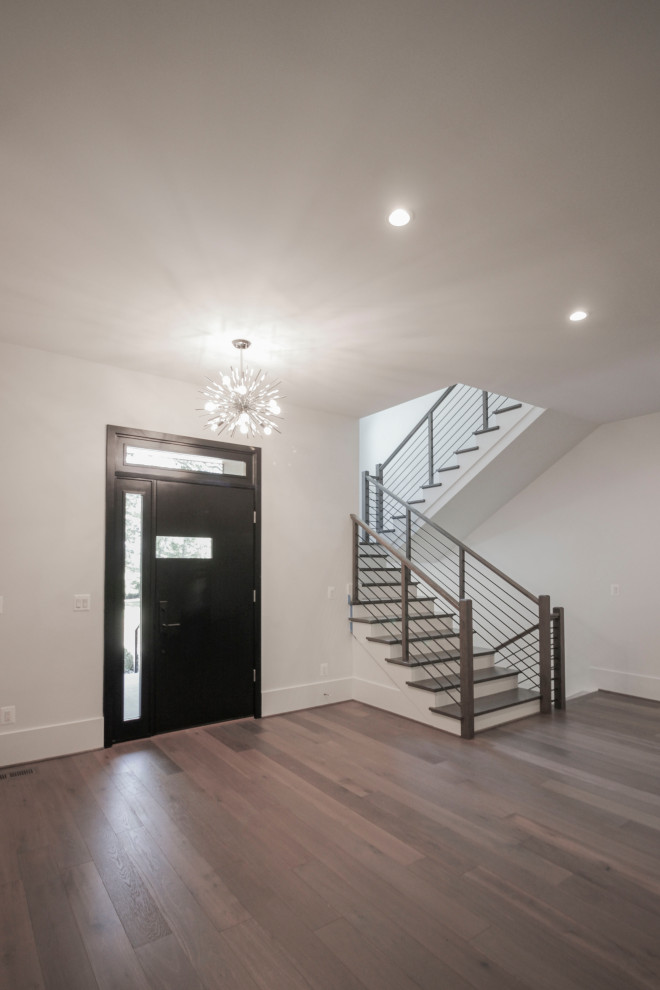 Photo of a mid-sized transitional wood u-shaped staircase in DC Metro with wood risers, metal railing and panelled walls.