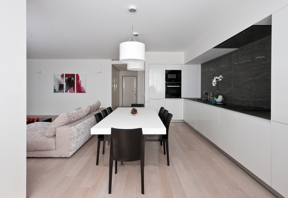 This is an example of a contemporary open plan dining in Moscow with light hardwood floors.