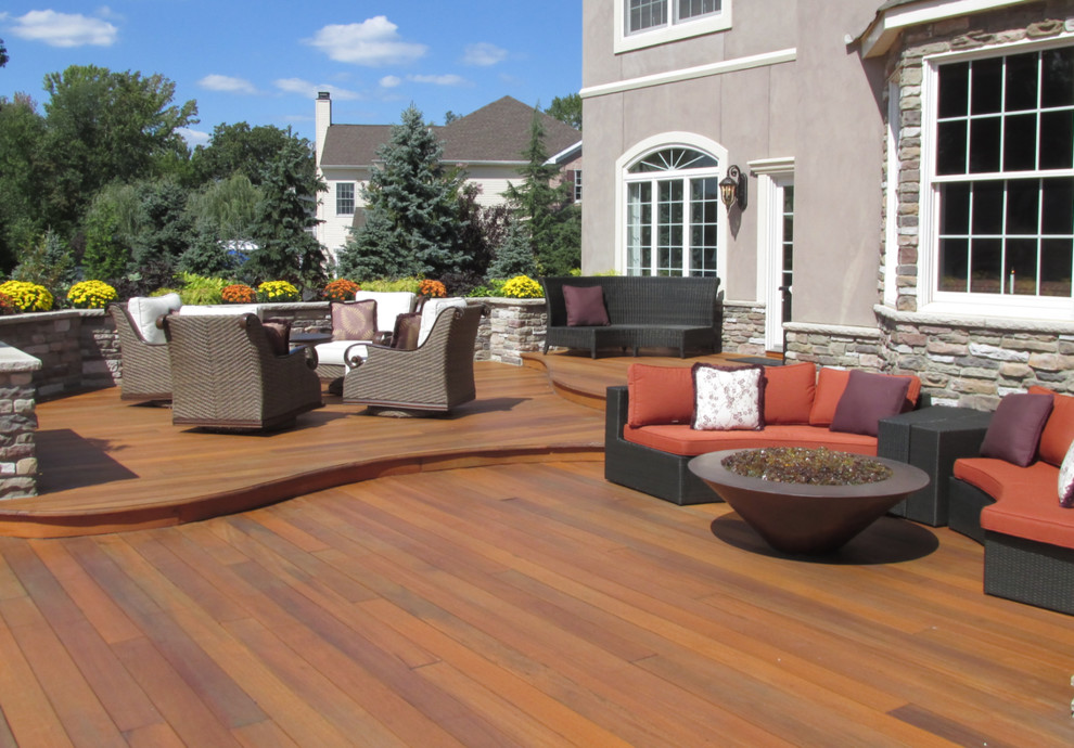 Photo of a large mediterranean backyard patio in New York with a fire feature, decking and no cover.