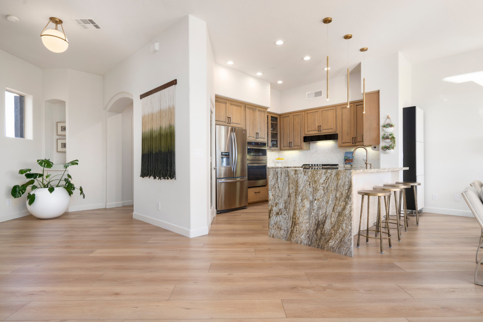 Inspiration for a mid-sized modern l-shaped open plan kitchen in Phoenix with a drop-in sink, beaded inset cabinets, light wood cabinets, marble benchtops, white splashback, cement tile splashback, stainless steel appliances, vinyl floors, with island, beige floor and multi-coloured benchtop.