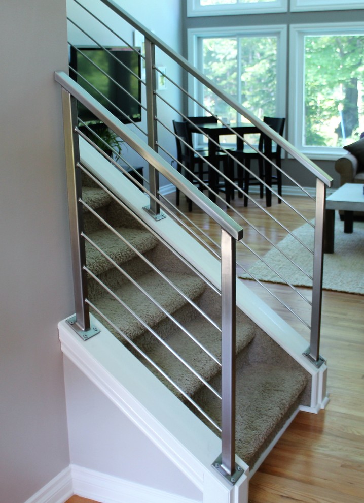 Inspiration for a mid-sized contemporary carpeted straight staircase in Detroit with carpet risers and metal railing.