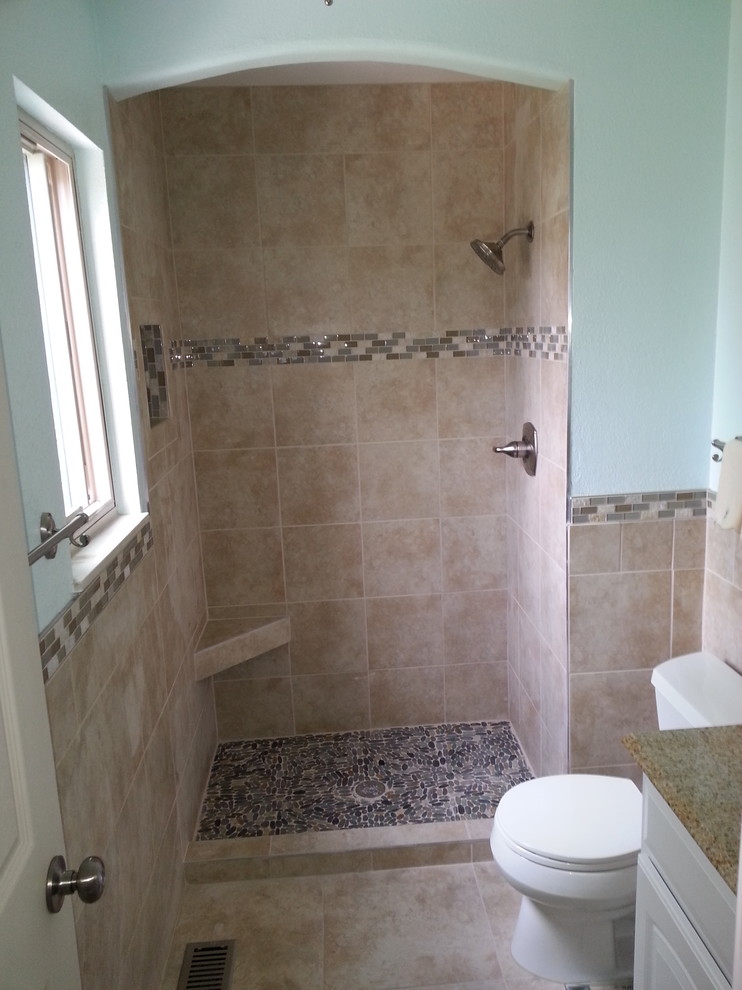 Alcove shower - mid-sized transitional 3/4 beige tile and porcelain tile porcelain tile and beige floor alcove shower idea with raised-panel cabinets, white cabinets, a two-piece toilet, blue walls, an undermount sink, laminate countertops, a hinged shower door and multicolored countertops