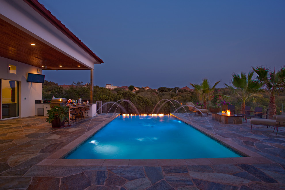 Inspiration for a mid-sized rustic backyard stone and rectangular infinity pool remodel in Austin