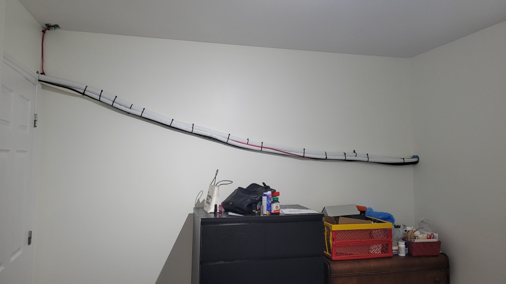 How can I hide heat pump lines on a bedroom wall?