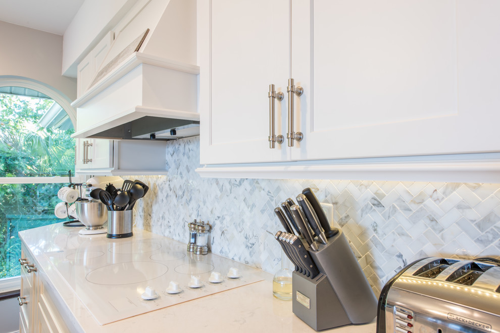 Eat-in kitchen - large transitional u-shaped porcelain tile and brown floor eat-in kitchen idea with an undermount sink, shaker cabinets, white cabinets, quartz countertops, white backsplash, marble backsplash, stainless steel appliances and two islands