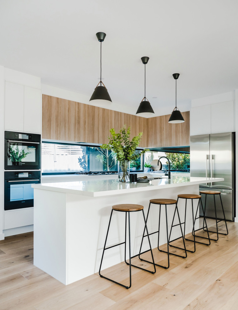 Design ideas for a mid-sized contemporary galley eat-in kitchen in Melbourne with white cabinets, with island and white benchtop.