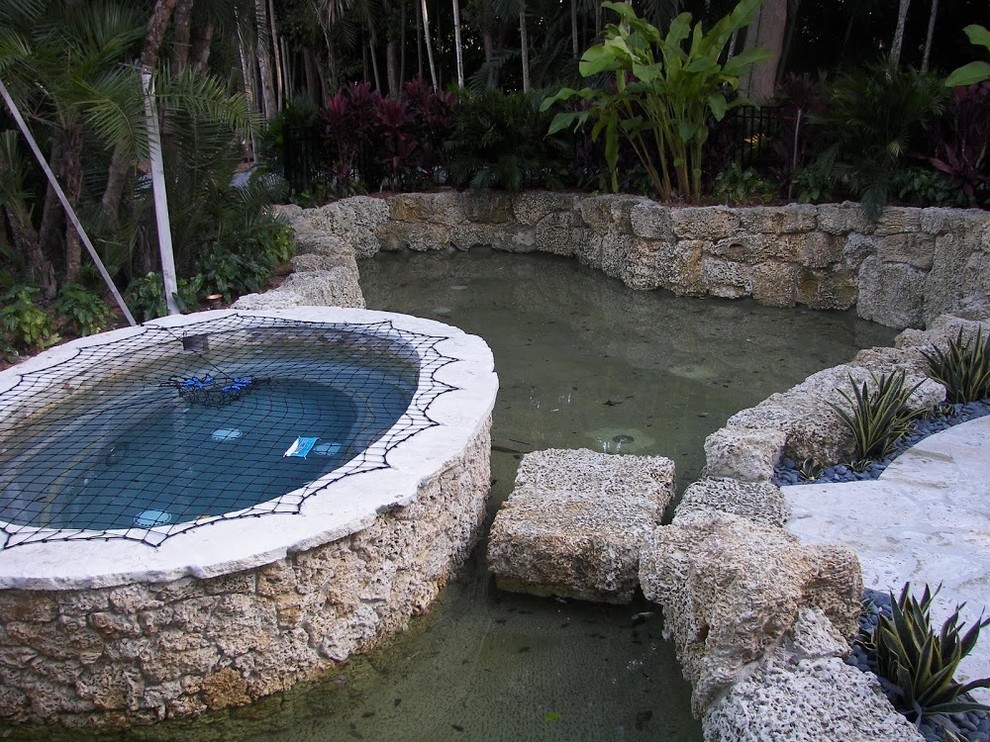 Pool fountain - transitional backyard stone and custom-shaped aboveground pool fountain idea in Miami
