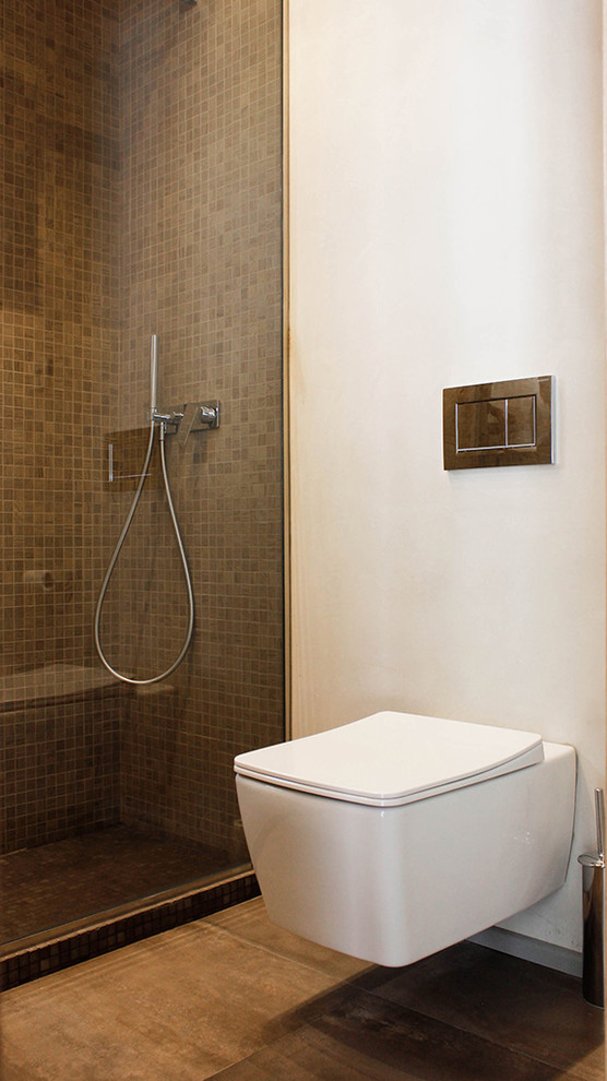 Inspiration for a mid-sized contemporary 3/4 bathroom in Other with a curbless shower, a wall-mount toilet, brown tile, mosaic tile, grey walls, medium hardwood floors and an open shower.
