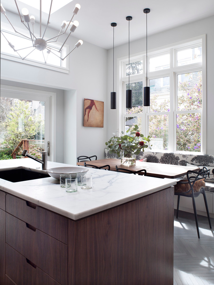 Photo of a contemporary eat-in kitchen in San Francisco with a single-bowl sink, flat-panel cabinets and dark wood cabinets.