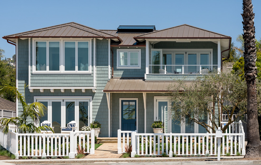This is an example of a mid-sized beach style two-storey blue exterior in Santa Barbara with wood siding and a hip roof.