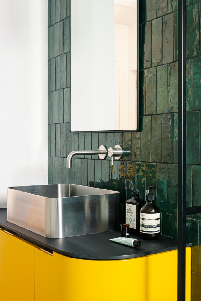 Large modern 3/4 bathroom in Milan with beaded inset cabinets, yellow cabinets, an open shower, a wall-mount toilet, green tile, ceramic tile, green walls, marble floors, a vessel sink, laminate benchtops, grey floor and black benchtops.