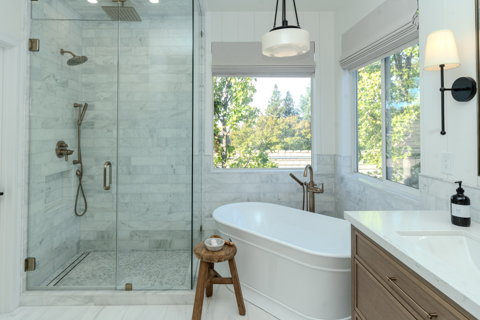 Modern inredning av ett stort en-suite badrum, med ett fristående badkar, vit kakel, marmorkakel, marmorgolv, vitt golv och dusch med gångjärnsdörr