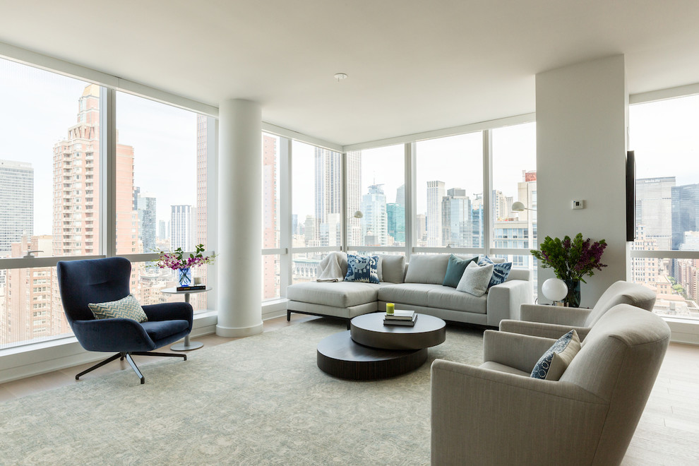 Photo of a mid-sized contemporary living room in New York with white walls, light hardwood floors and beige floor.