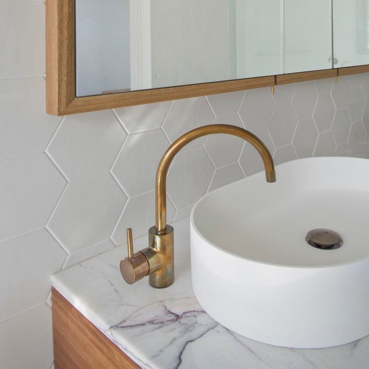 This is an example of a mid-sized master bathroom in Melbourne with a vessel sink, flat-panel cabinets, medium wood cabinets, marble benchtops, a freestanding tub, an open shower, a one-piece toilet, white tile, ceramic tile, white walls and slate floors.