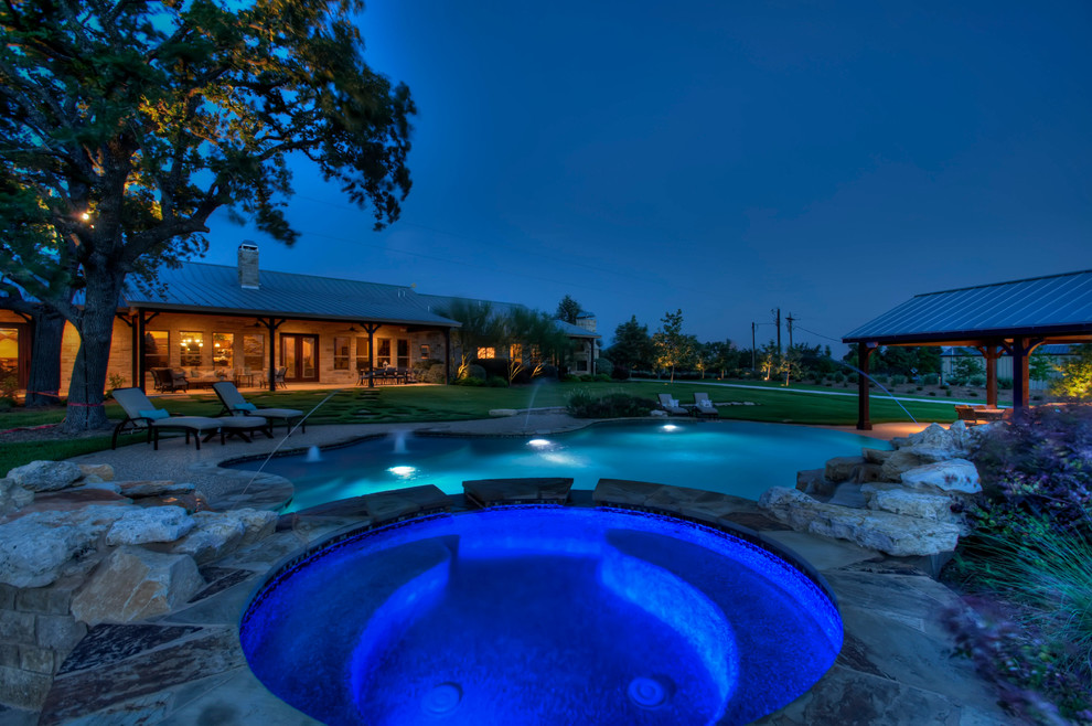 Inspiration for a mid-sized transitional backyard stone and custom-shaped natural hot tub remodel in Austin