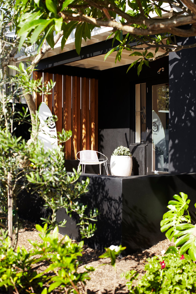 Inspiration for a mid-sized contemporary front door in Sydney with black walls, limestone floors, a black front door and a single front door.