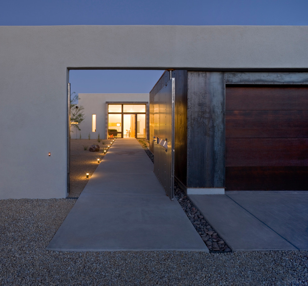 This is an example of a modern entryway in Phoenix with concrete floors and a pivot front door.