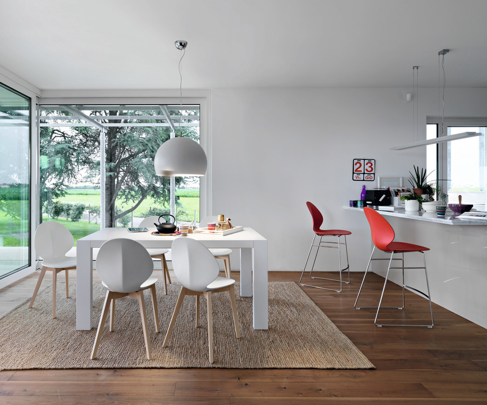 This is an example of a contemporary kitchen/dining combo in Toronto with white walls and dark hardwood floors.