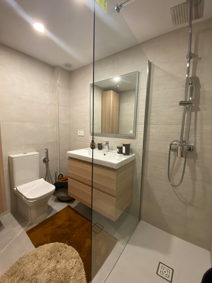 Inspiration for a mid-sized master bathroom in Madrid with flat-panel cabinets, light wood cabinets, an open shower, a one-piece toilet, gray tile, ceramic tile, grey walls, ceramic floors, a drop-in sink, engineered quartz benchtops, grey floor, an open shower, white benchtops, a single vanity, a floating vanity and recessed.
