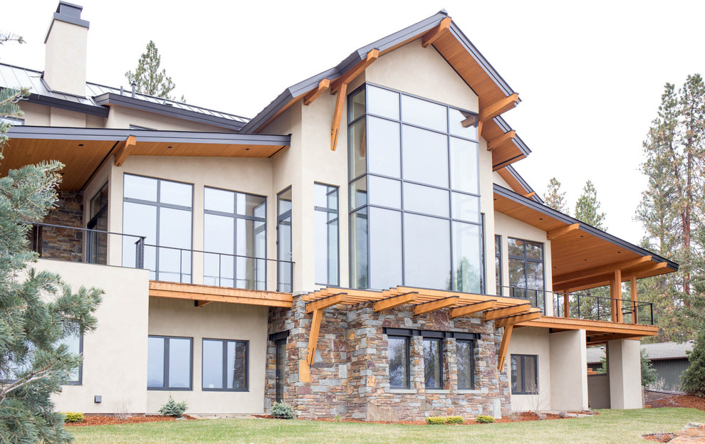 Large mountain style beige three-story stucco gable roof photo