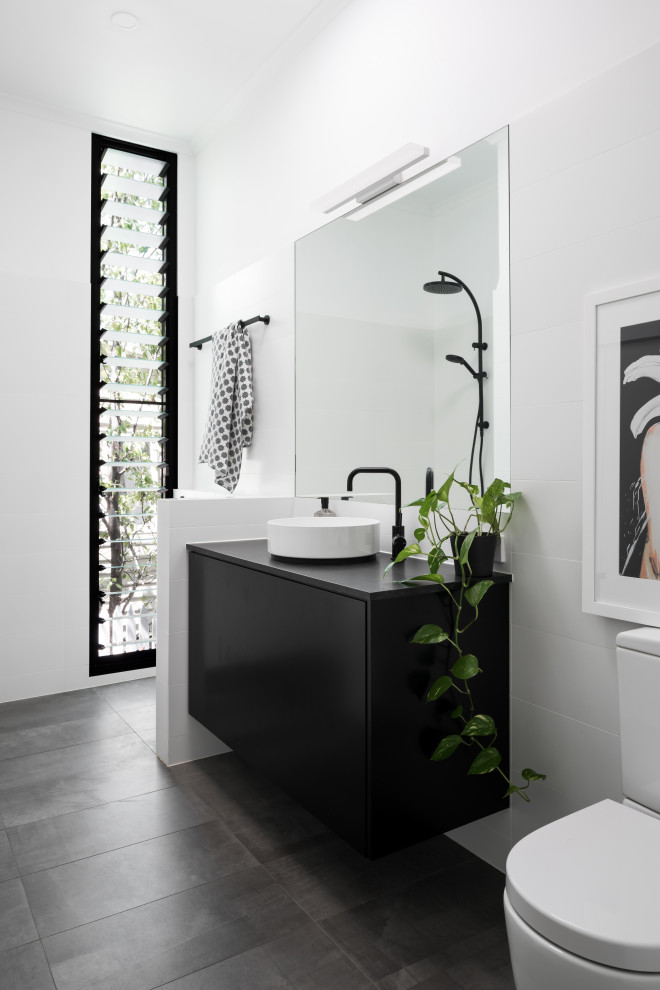 Contemporary 3/4 bathroom in Perth with flat-panel cabinets, black cabinets, white tile, white walls, a vessel sink, grey floor, black benchtops, a single vanity and a floating vanity.