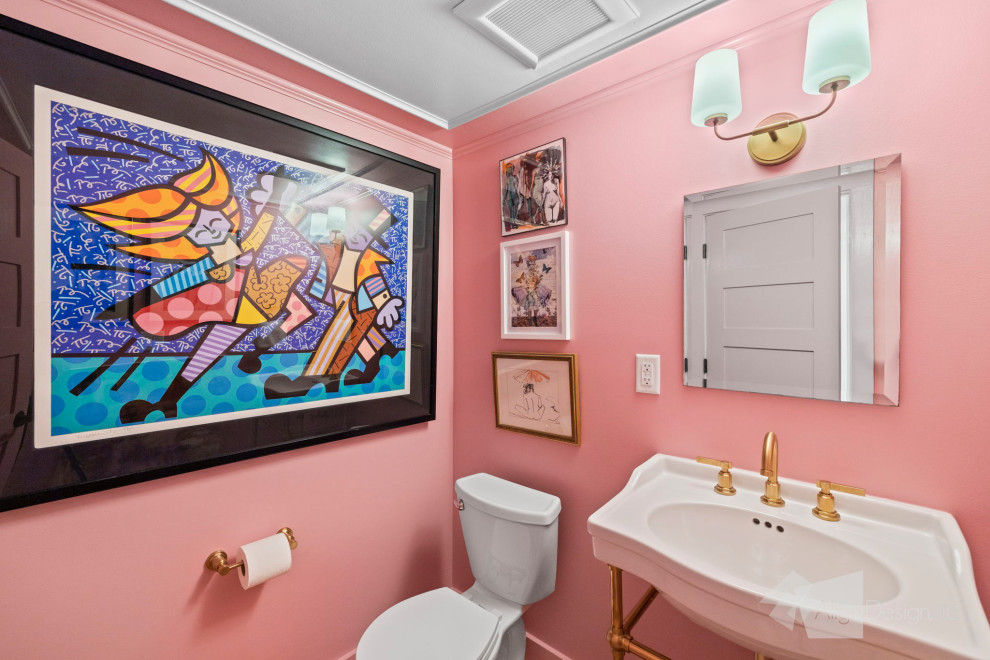 Photo of a small eclectic powder room in Other with white cabinets, a one-piece toilet, pink walls, light hardwood floors, brown floor and a freestanding vanity.