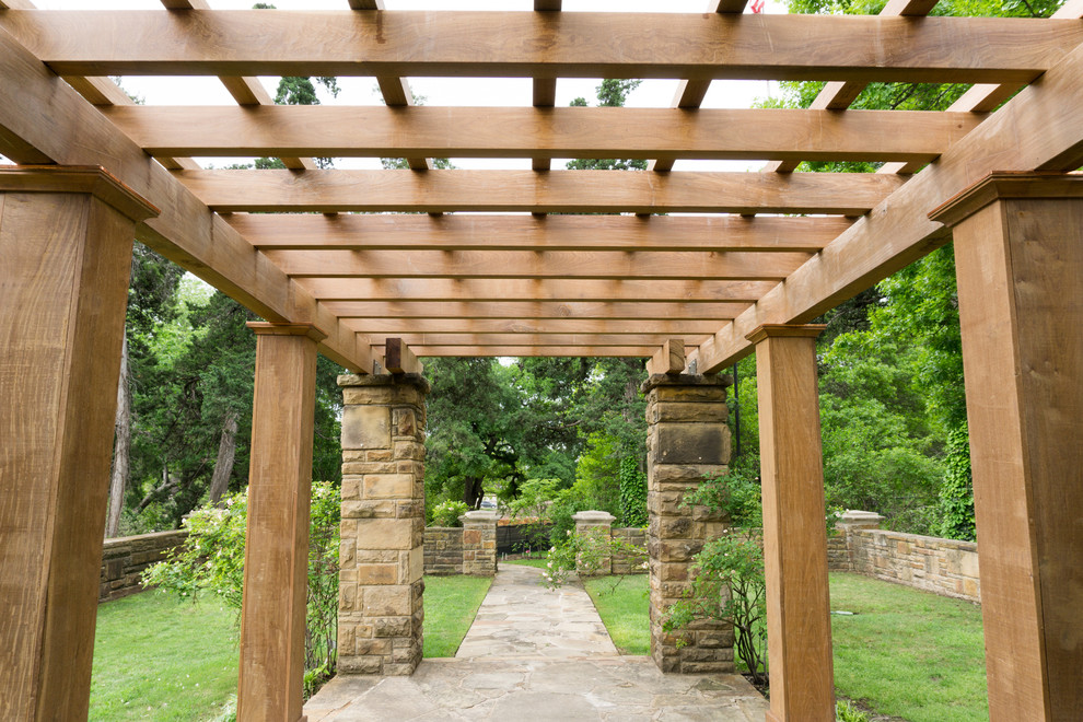 Inspiration for a large country courtyard patio in Dallas with a water feature, natural stone pavers and a pergola.