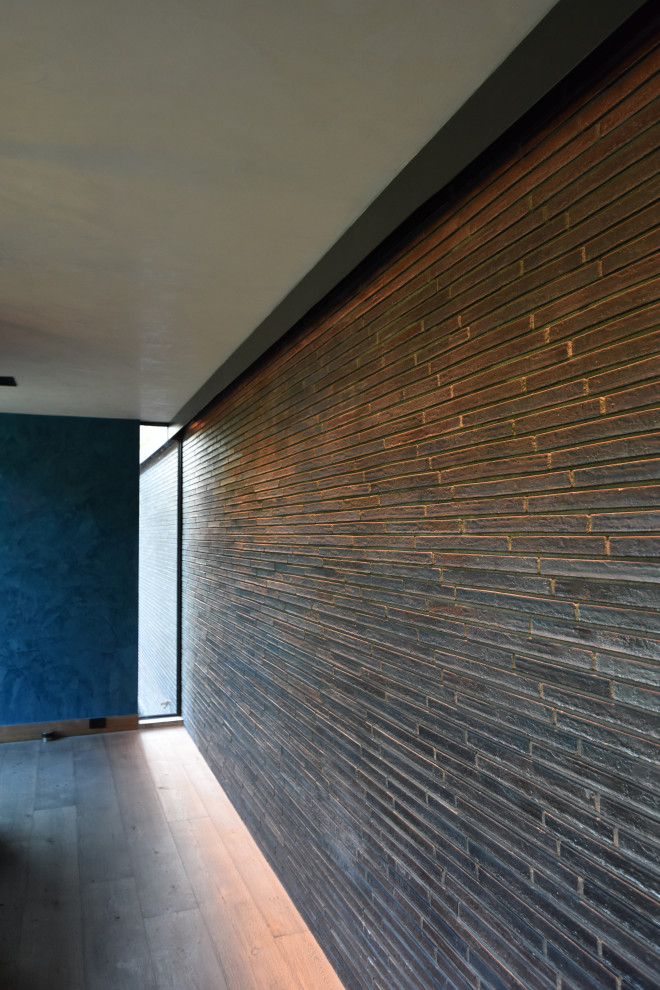 Mittelgroßes Modernes Foyer mit schwarzer Wandfarbe, hellem Holzboden, Einzeltür, schwarzer Haustür, braunem Boden, eingelassener Decke und Ziegelwänden in Houston
