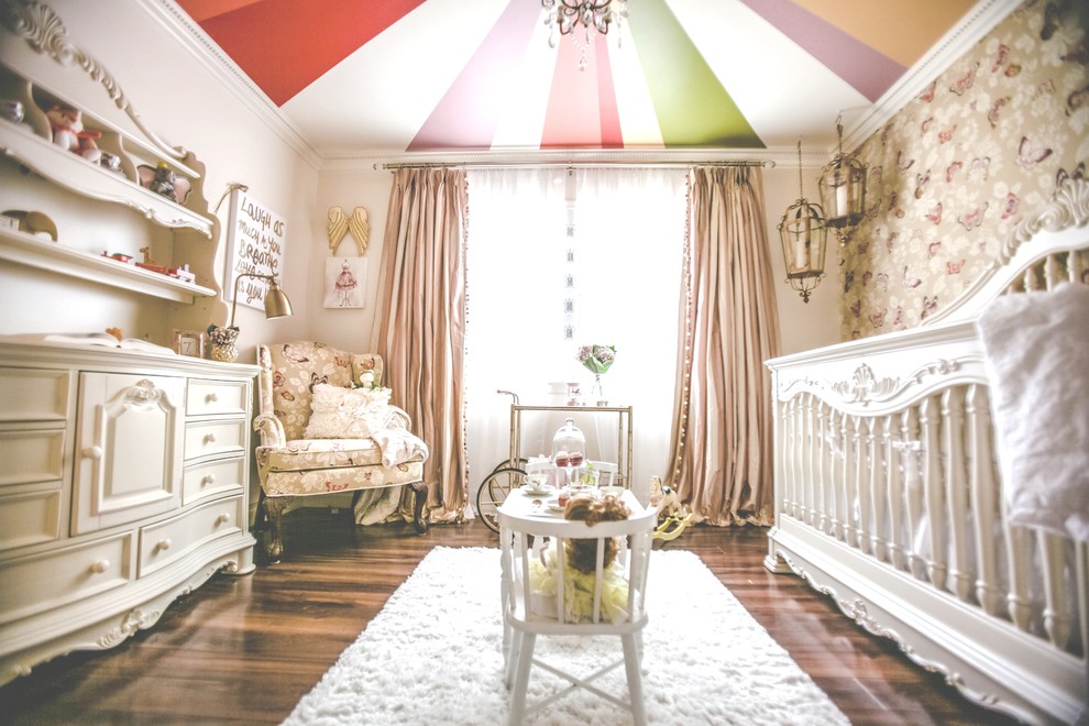 This is an example of a mid-sized traditional nursery for girls in Las Vegas with dark hardwood floors and white walls.