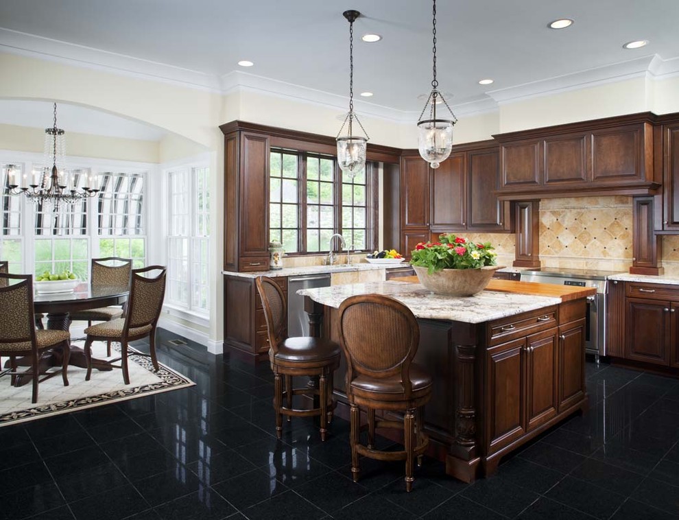 Photo of a traditional eat-in kitchen in San Diego with raised-panel cabinets, medium wood cabinets, beige splashback, stainless steel appliances and black floor.