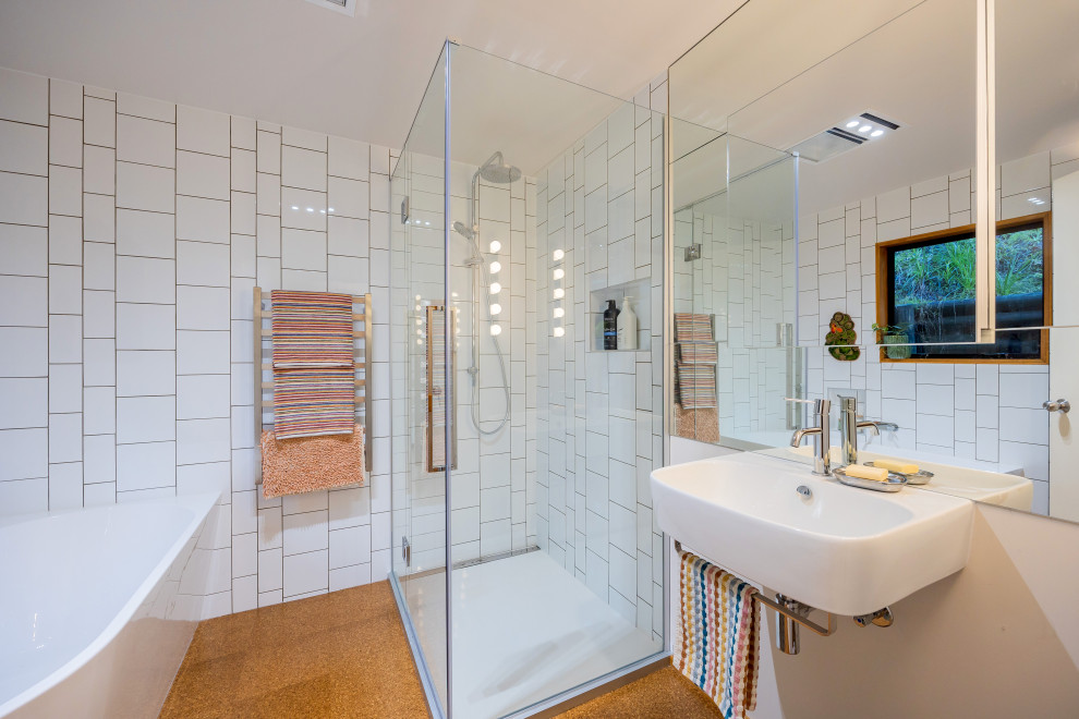 Design ideas for a small eclectic bathroom in Auckland with white cabinets, a corner tub, a corner shower, white tile, ceramic tile, white walls, cork floors, a wall-mount sink, brown floor, a hinged shower door, a single vanity and a floating vanity.