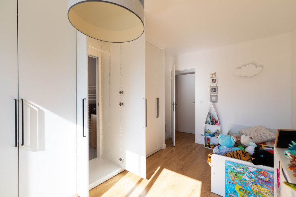 Exemple d'une chambre d'enfant de 4 à 10 ans moderne de taille moyenne avec un mur blanc et parquet clair.