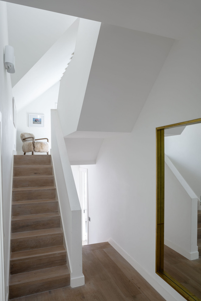 Großer Moderner Flur mit weißer Wandfarbe, hellem Holzboden, beigem Boden und eingelassener Decke in London