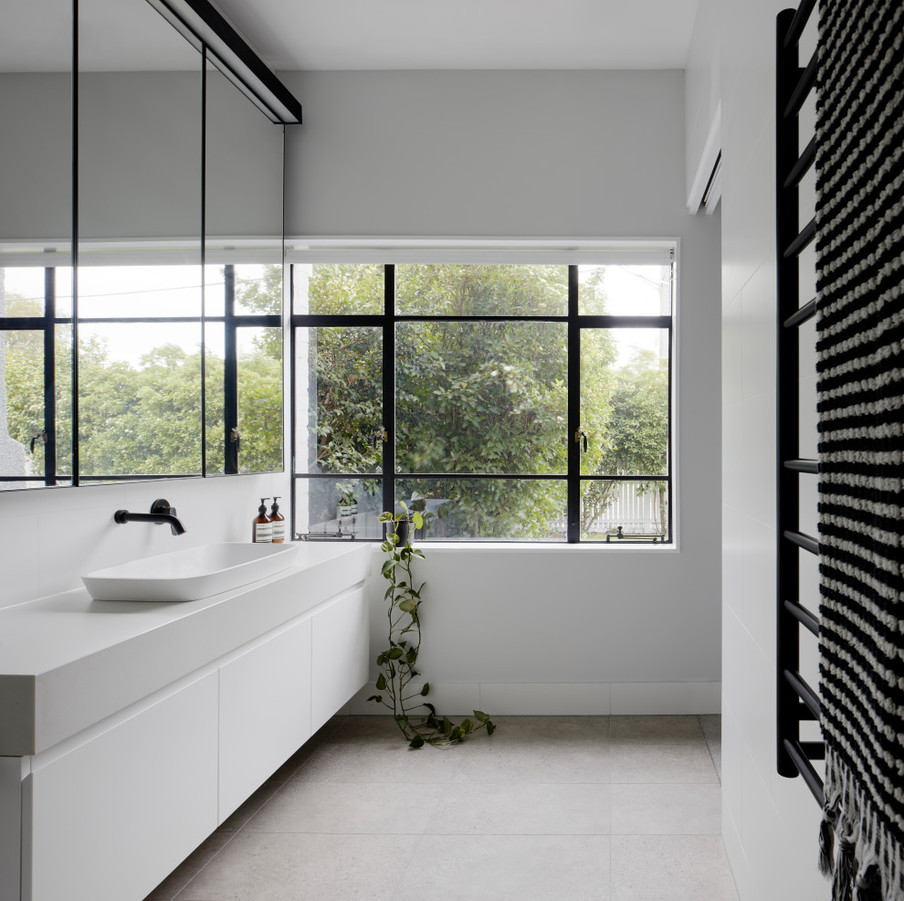 Design ideas for a contemporary bathroom in Melbourne with white tile, porcelain tile, porcelain floors, engineered quartz benchtops, a single vanity, a floating vanity, flat-panel cabinets, white cabinets, white walls, a vessel sink, grey floor and white benchtops.