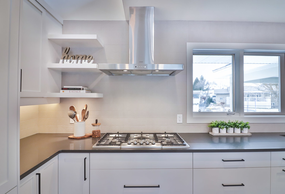 Large transitional l-shaped vinyl floor and brown floor open concept kitchen photo with an undermount sink, flat-panel cabinets, white cabinets, quartz countertops, gray backsplash, porcelain backsplash, stainless steel appliances and an island