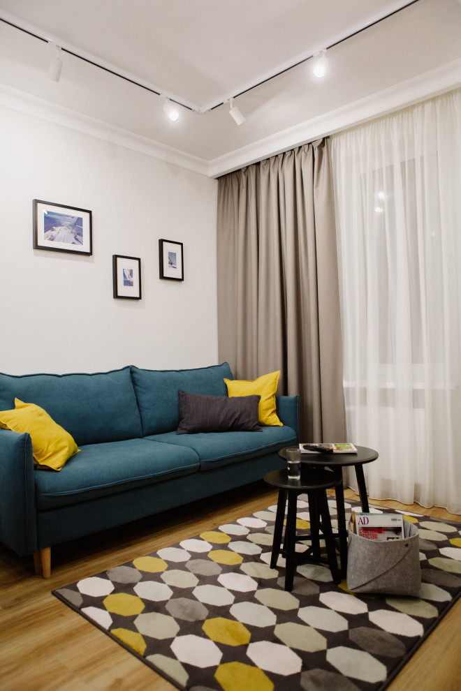 Свежая идея для дизайна: гостиная комната среднего размера, в белых тонах с отделкой деревом в современном стиле с бежевыми стенами, телевизором на стене, желтым полом, обоями на стенах и синим диваном - отличное фото интерьера