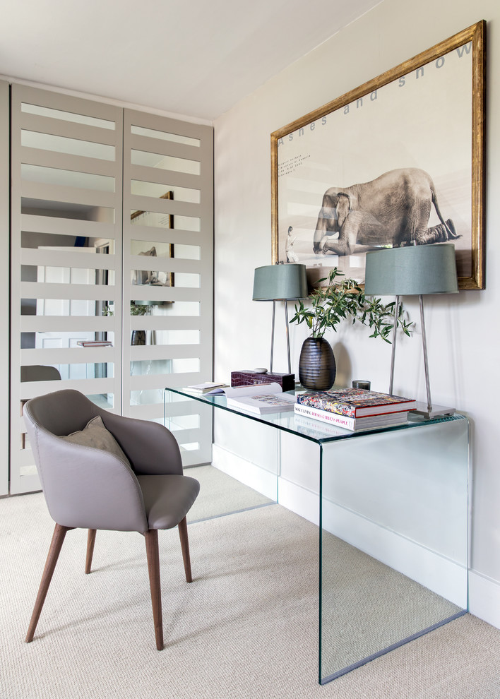 Mid-sized transitional home office in London with white walls, carpet, a freestanding desk and beige floor.