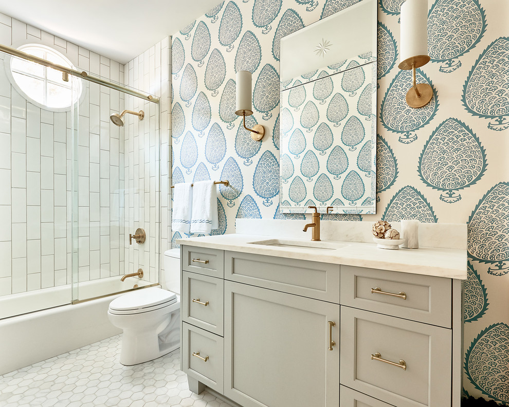 Design ideas for a beach style bathroom in Charlotte with recessed-panel cabinets, grey cabinets, a shower/bathtub combo, a two-piece toilet, white tile, multi-coloured walls and a sliding shower screen.
