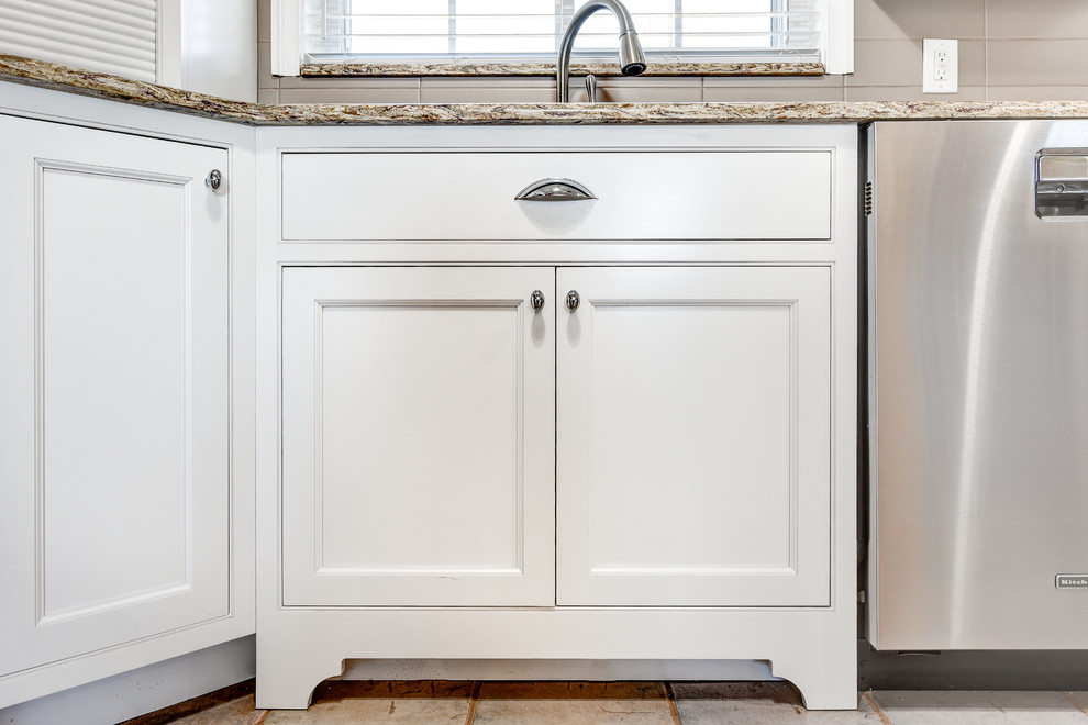 Example of a mid-sized classic u-shaped ceramic tile eat-in kitchen design with an undermount sink, recessed-panel cabinets, white cabinets, granite countertops, beige backsplash, ceramic backsplash, stainless steel appliances and no island