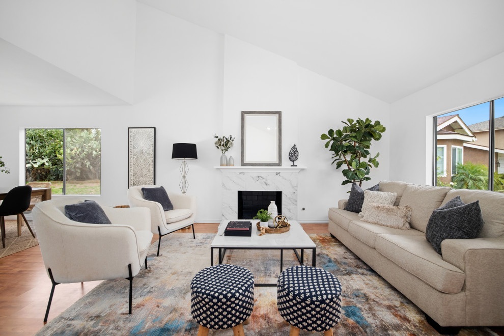 Diseño de salón abierto minimalista de tamaño medio con paredes blancas, suelo laminado y todas las chimeneas