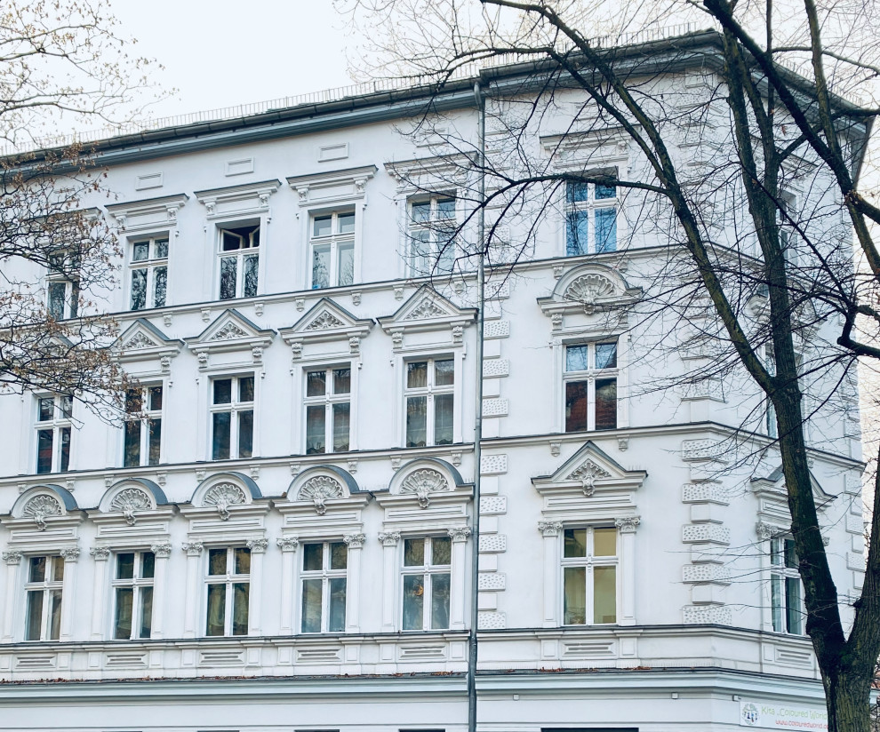 Großes Klassisches Haus mit Mix-Fassade, weißer Fassadenfarbe, Flachdach, Ziegeldach und grauem Dach in Berlin