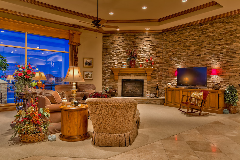 Large traditional formal open concept living room in Omaha with brown walls, carpet, a stone fireplace surround, a freestanding tv, a standard fireplace and beige floor.