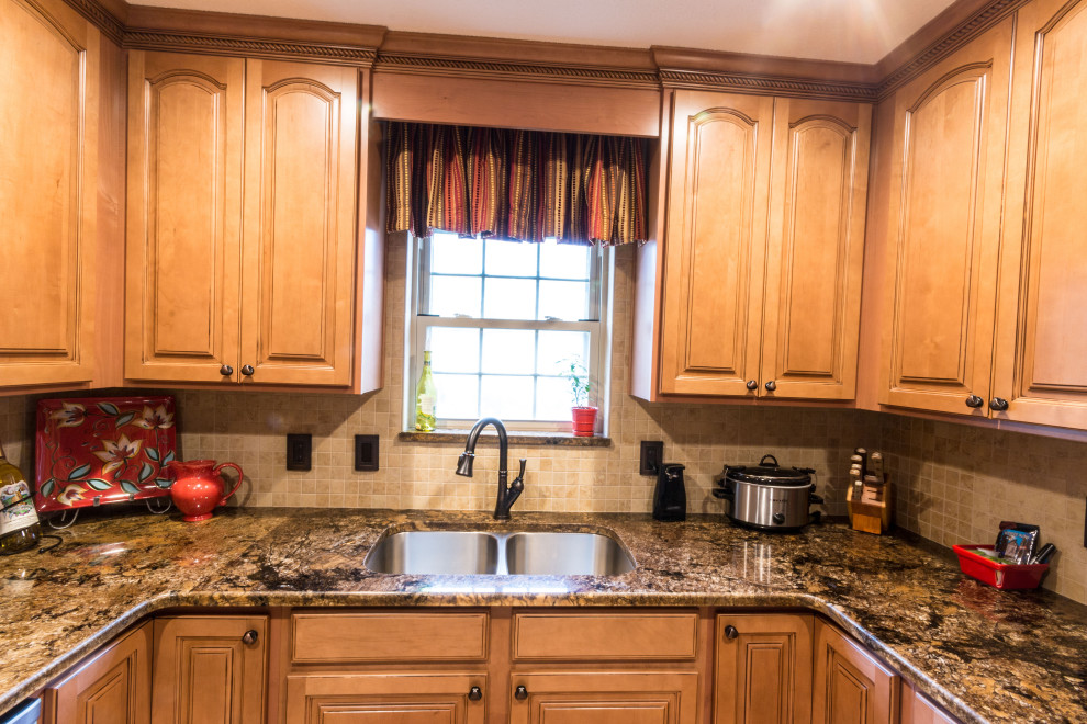 Inspiration for a mid-sized u-shaped cement tile floor and beige floor eat-in kitchen remodel with an undermount sink, raised-panel cabinets, medium tone wood cabinets, granite countertops, stainless steel appliances, no island and brown countertops