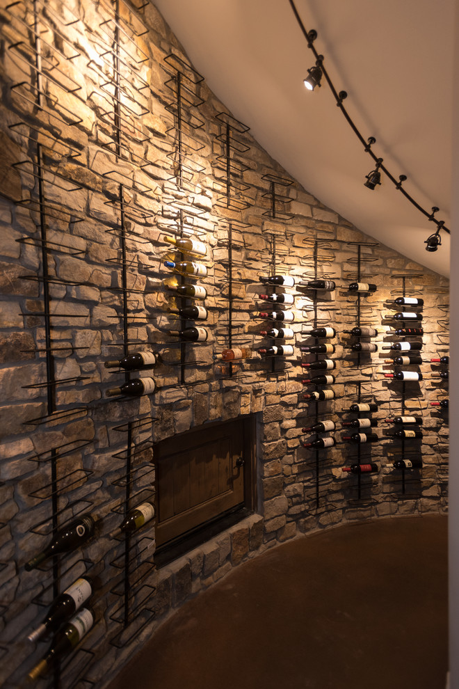 Inspiration for a large wine cellar in Denver with concrete floors, display racks and brown floor.